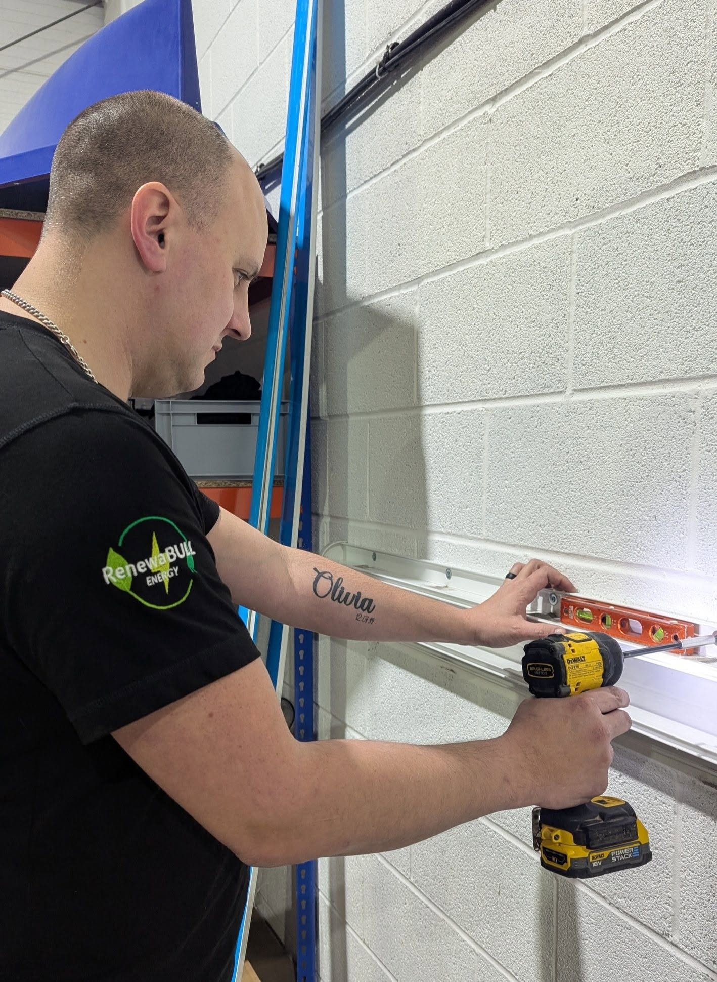 RenewaBULL installer preparing a brick wall for an EV charger installation.
