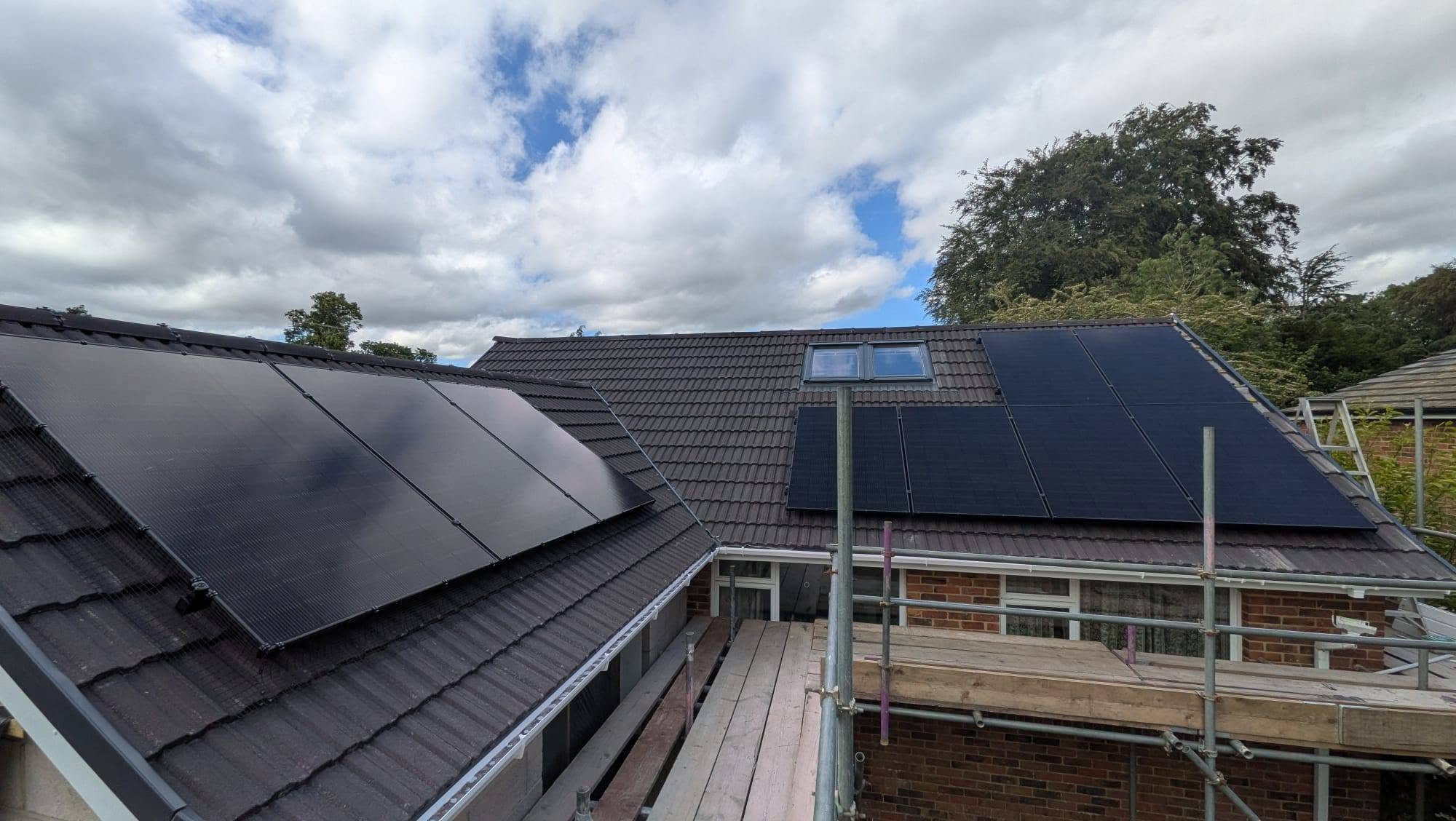 Multiple solar panel arrays installed across neighbouring residential roofs.